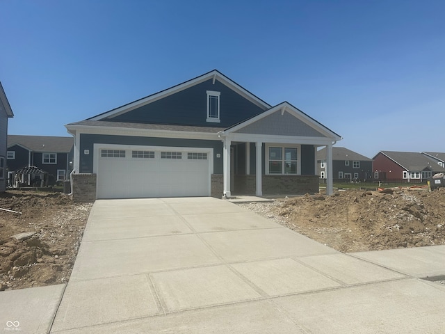 1644 Winn Ct, Fortville, IN 46040 - view of front facade with brick siding, an attached garage, driveway, and covered porch