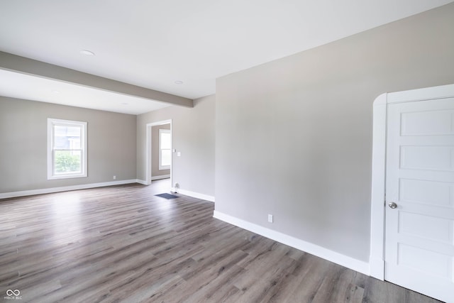 empty room with baseboards, wood finished floors, and recessed lighting