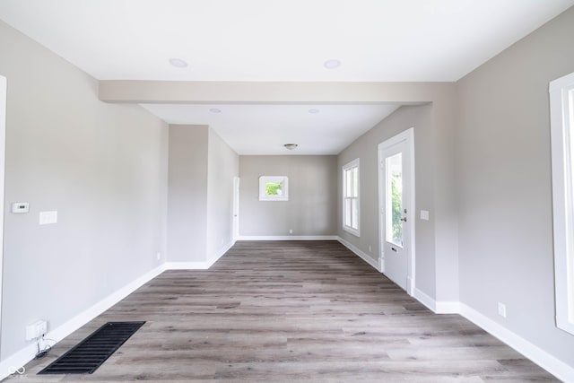 interior space featuring baseboards, wood finished floors, and visible vents