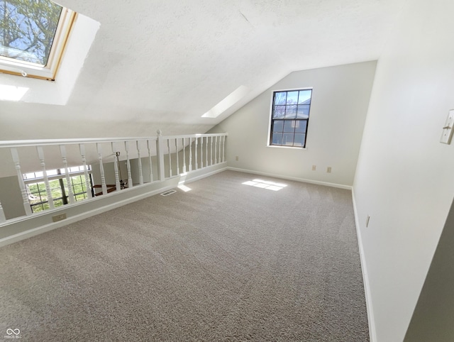 9162 Hadway Dr, Indianapolis, IN 46256 - additional living space with baseboards, vaulted ceiling with skylight, visible vents, and carpet