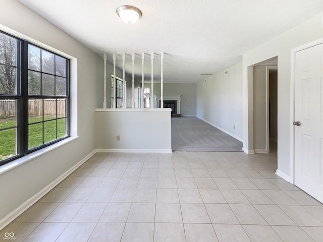 9162 Hadway Dr, Indianapolis, IN 46256 - spare room with baseboards, a wealth of natural light, and a fireplace with raised hearth