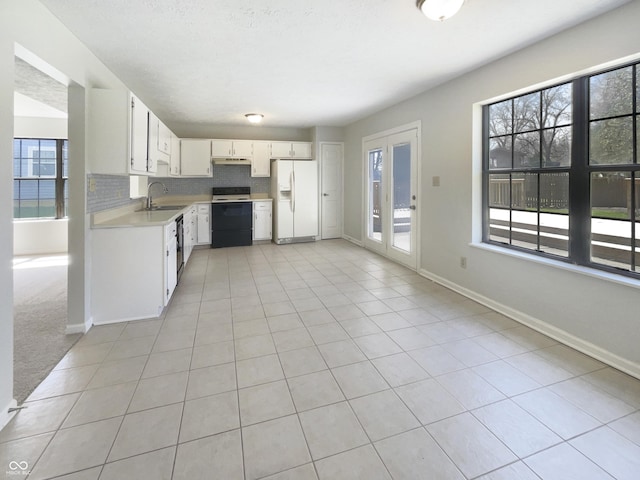 9162 Hadway Dr, Indianapolis, IN 46256 - kitchen featuring range with electric stovetop, under cabinet range hood, light countertops, a sink, and white refrigerator with ice dispenser