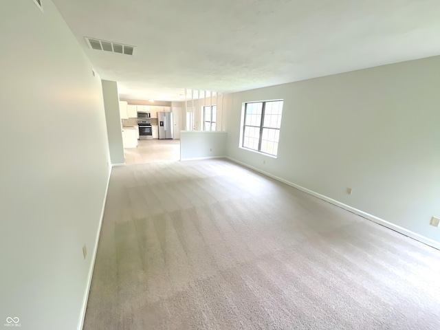 9162 Hadway Dr, Indianapolis, IN 46256 - unfurnished living room with baseboards and light colored carpet