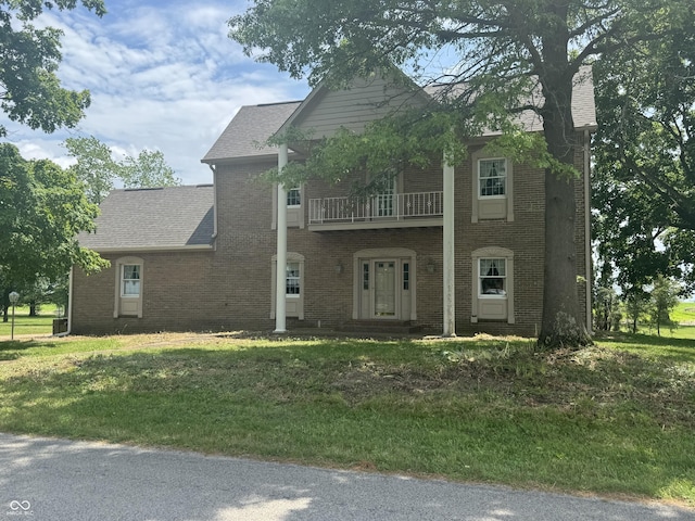 2365 E 850 N, Lebanon, IN 46052 - view of front of home featuring a balcony, a front yard, brick siding, a chimney, and roof with shingles