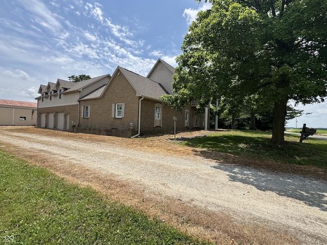 2365 E 850 N, Lebanon, IN 46052 - view of property exterior with brick siding, dirt driveway, an attached garage, and a lawn