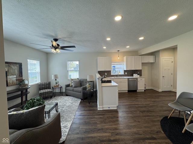 living area with plenty of natural light, recessed lighting, a textured ceiling, and dark wood finished floors