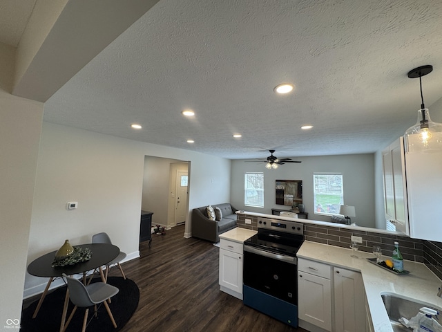 kitchen with a sink, stainless steel electric stove, open floor plan, a peninsula, and recessed lighting