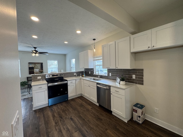 kitchen featuring recessed lighting, dark wood-style floors, stainless steel appliances, a sink, and a peninsula
