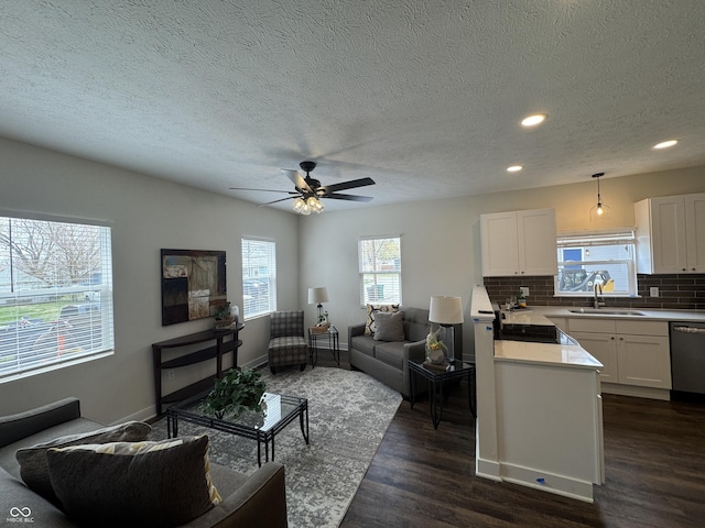living area with dark wood-style floors, a textured ceiling, baseboards, recessed lighting, and a ceiling fan