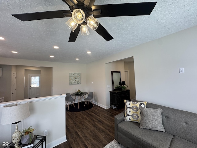 living room with a ceiling fan, dark wood-type flooring, a textured ceiling, and recessed lighting