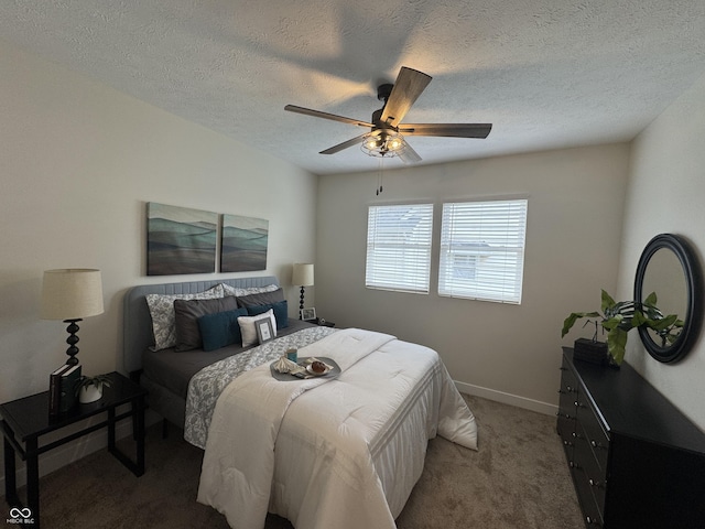 carpeted bedroom featuring a textured ceiling, baseboards, and ceiling fan