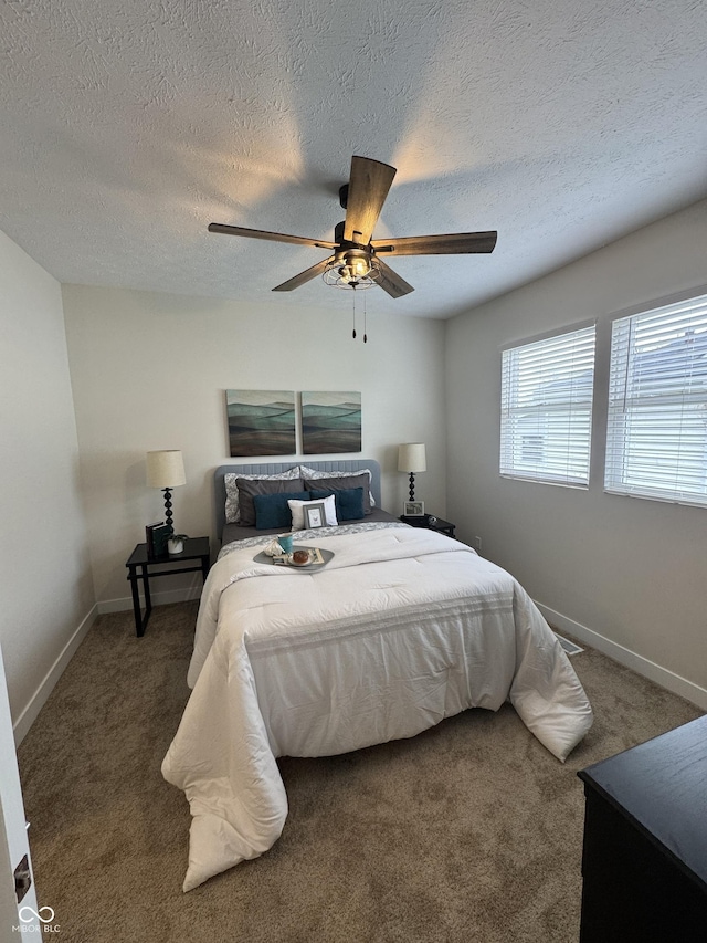 bedroom featuring baseboards, carpet flooring, a textured ceiling, and ceiling fan