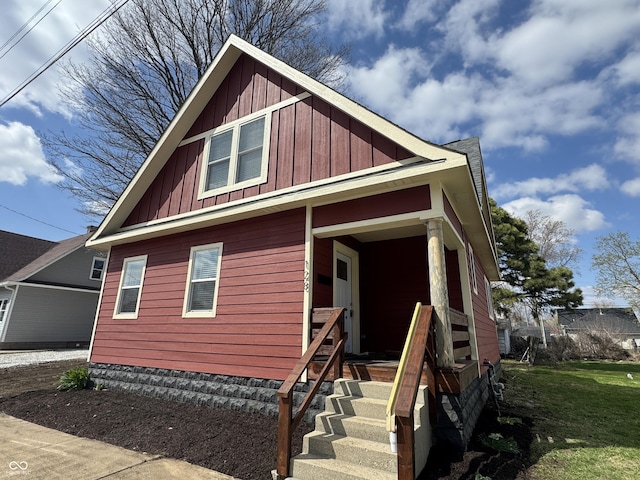view of front facade with board and batten siding and a front yard