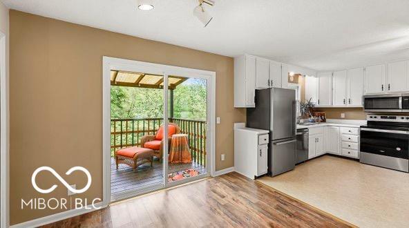 kitchen featuring white cabinets, stainless steel appliances, and light countertops