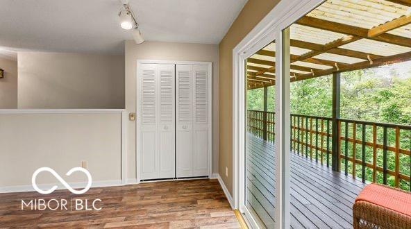 doorway to outside with track lighting, baseboards, and wood finished floors