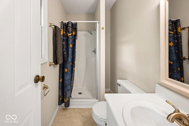 full bath featuring a sink, a textured ceiling, toilet, a stall shower, and baseboards