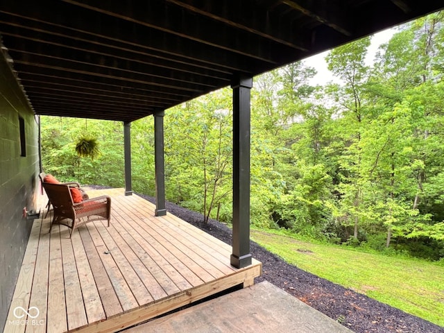 wooden terrace featuring a wooded view