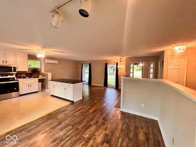 kitchen with plenty of natural light, appliances with stainless steel finishes, open floor plan, and white cabinetry