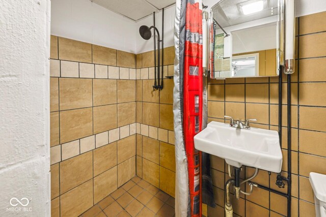 full bathroom with a sink and tiled shower