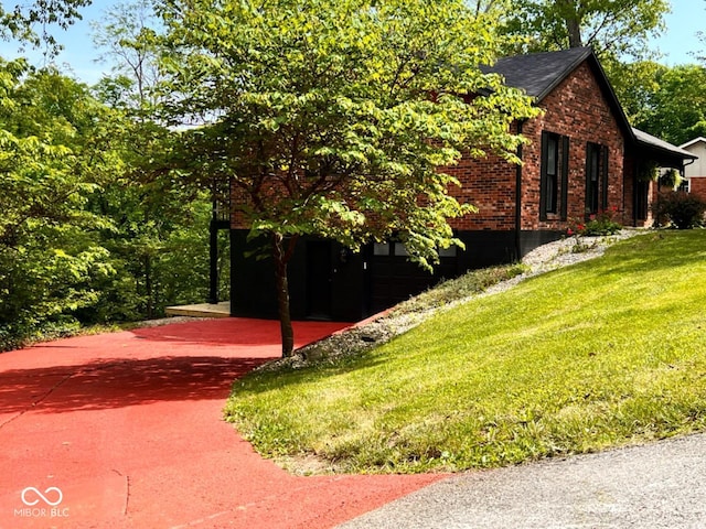 view of home's exterior featuring brick siding, a yard, and a shingled roof