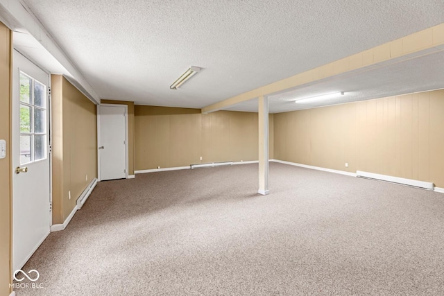 basement featuring a baseboard radiator, carpet flooring, and a textured ceiling