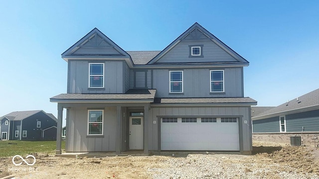 1656 Winn Ct, Fortville, IN 46040 - view of front of home with board and batten siding, a porch, a garage, and cooling unit
