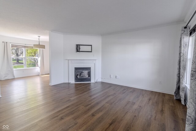 unfurnished living room with baseboards, dark wood finished floors, a tiled fireplace, and ornamental molding