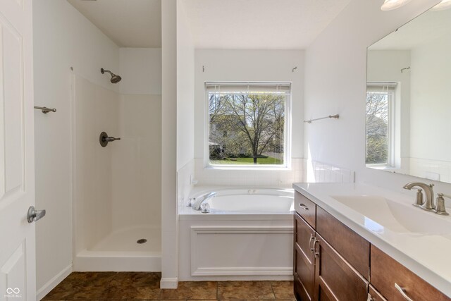 bathroom featuring a bath, vanity, and a shower
