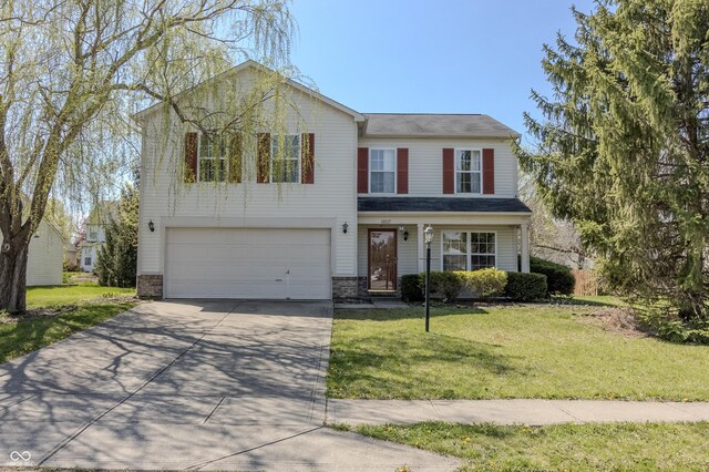 traditional-style house with an attached garage, driveway, and a front yard