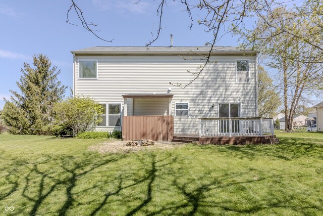 back of house featuring a lawn and a deck