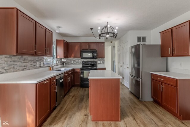 kitchen with light wood-style floors, visible vents, a sink, black appliances, and an inviting chandelier