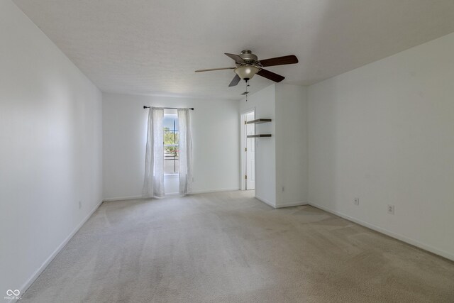 unfurnished room with light colored carpet, baseboards, and ceiling fan