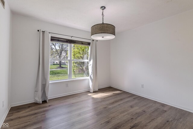 unfurnished dining area with baseboards, wood finished floors, and visible vents