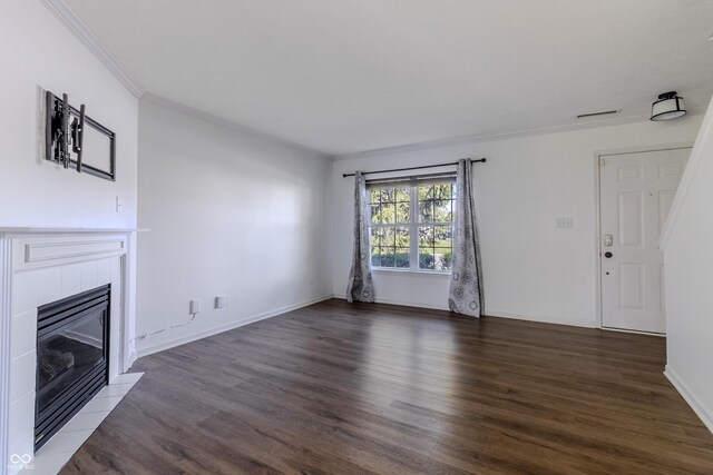 unfurnished living room with crown molding, baseboards, wood finished floors, and a fireplace