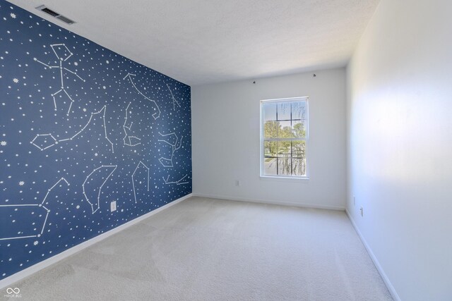 carpeted empty room with baseboards, wallpapered walls, and visible vents