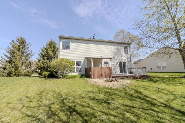 rear view of property featuring a wooden deck and a yard