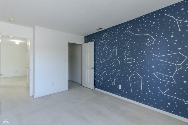 carpeted spare room featuring visible vents