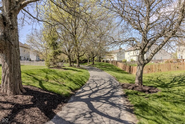 view of community with fence, a yard, and a residential view