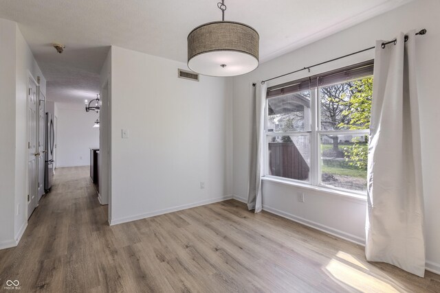 interior space featuring visible vents, baseboards, and wood finished floors
