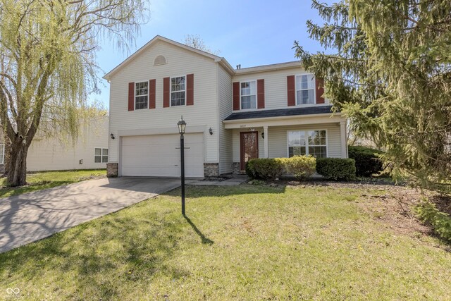 traditional-style home featuring an attached garage, driveway, and a front lawn