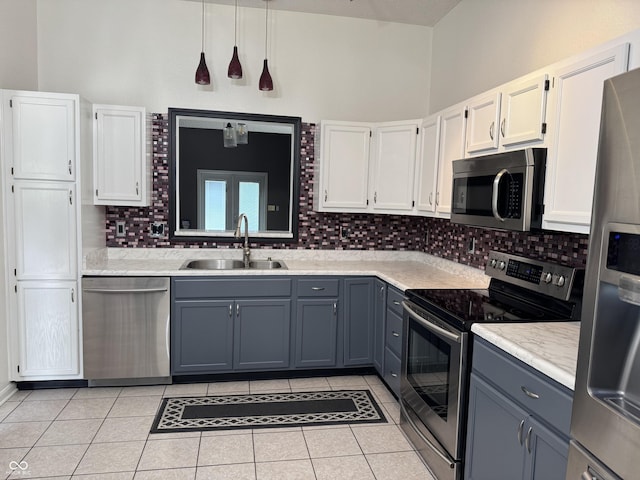 kitchen featuring decorative backsplash, appliances with stainless steel finishes, a sink, and light tile patterned flooring