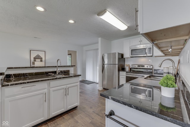 91 Crestview Dr, Greenwood, IN 46143 - kitchen featuring wood finished floors, appliances with stainless steel finishes, white cabinetry, and a sink