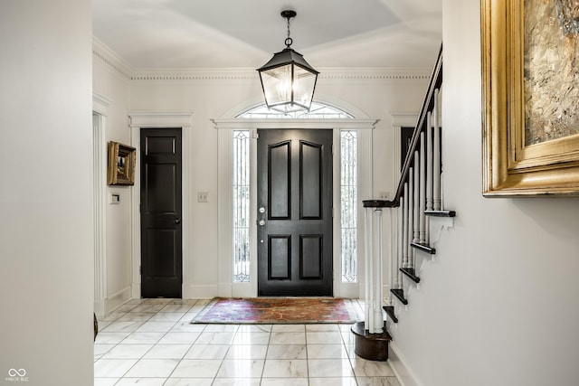 entryway featuring baseboards, ornamental molding, stairs, and marble finish floor