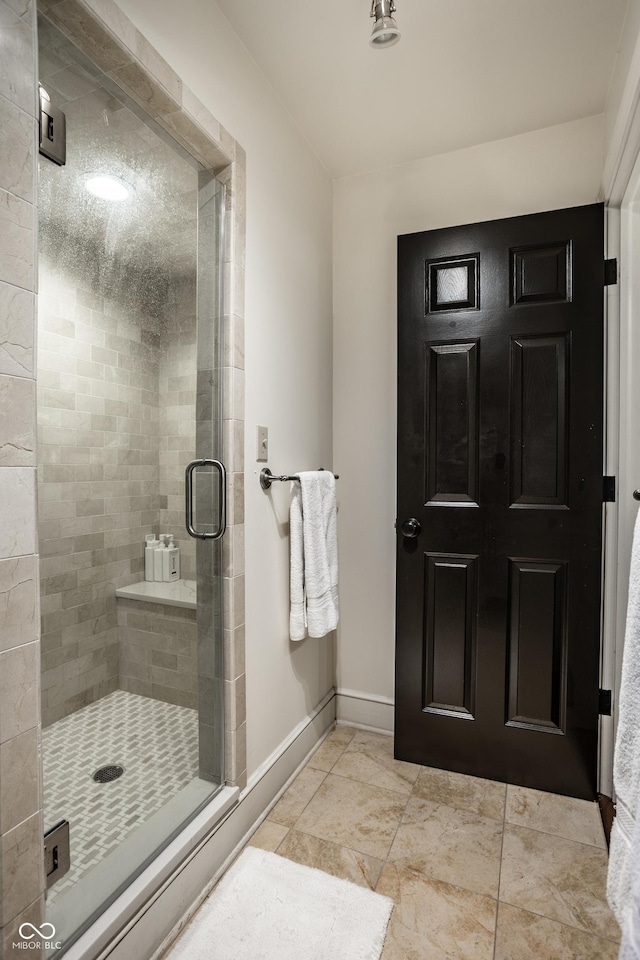 bathroom with a stall shower and baseboards