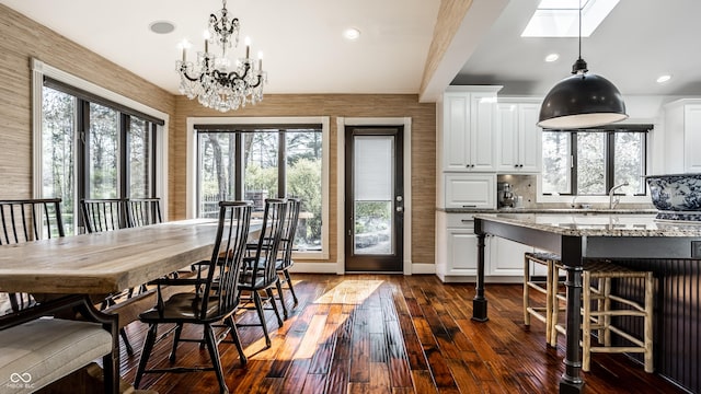 dining area featuring a chandelier, recessed lighting, a healthy amount of sunlight, and dark wood-style flooring