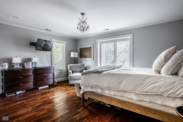 bedroom featuring wood finished floors, baseboards, visible vents, a notable chandelier, and crown molding