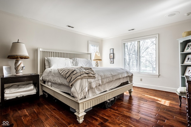 bedroom with baseboards, visible vents, hardwood / wood-style flooring, and crown molding