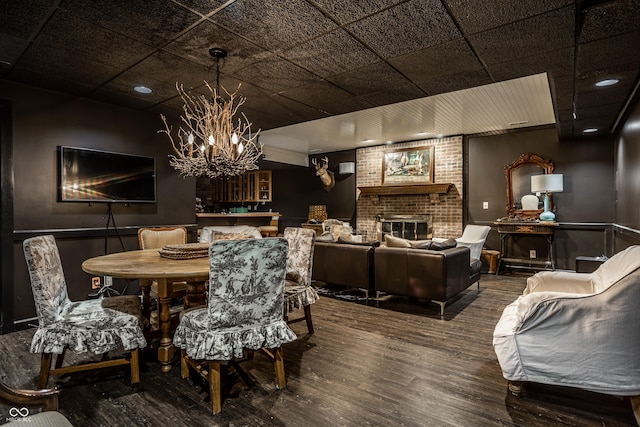 dining area with recessed lighting, wood finished floors, a notable chandelier, and a brick fireplace