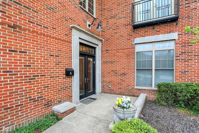 view of exterior entry with french doors and brick siding