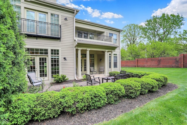 back of property featuring a balcony and a patio